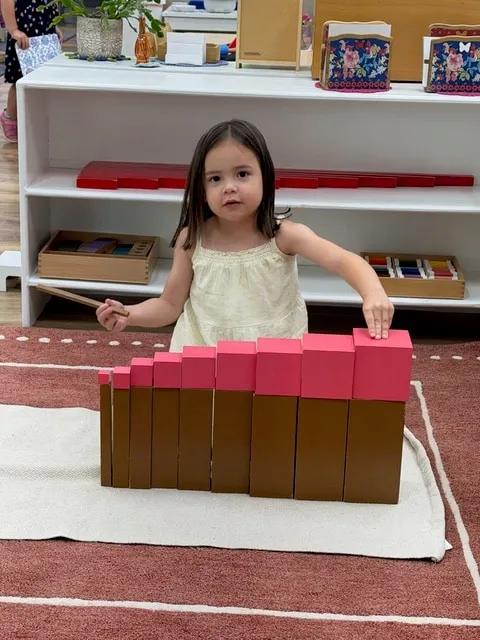 Girl building with the brown stair in the classroom