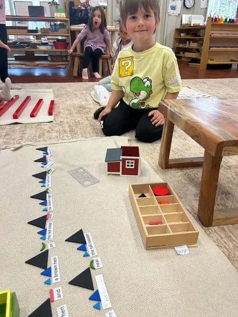 Boy working with bead chains and number arrows on the classroom floor